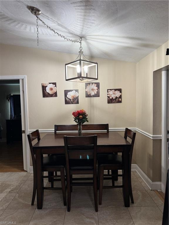 Dining area with a chandelier and a textured ceiling