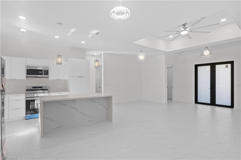 Kitchen with modern cabinets, stainless steel appliances, white cabinetry, and recessed lighting