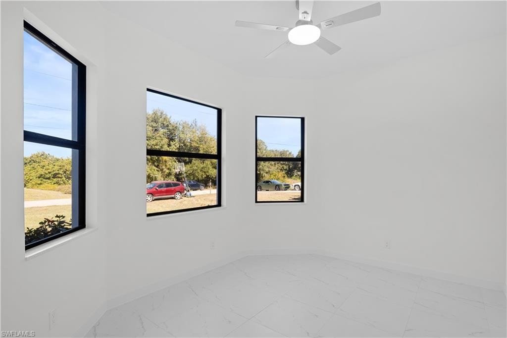Unfurnished bedroom with light marble finish flooring and a ceiling fan