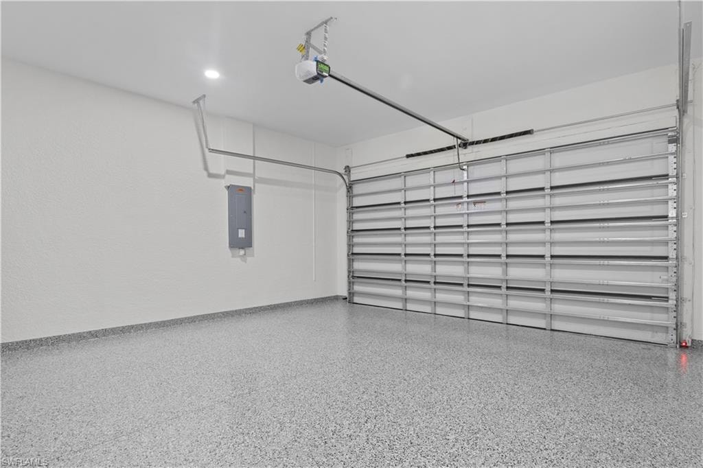Garage featuring electric panel and a garage door opener