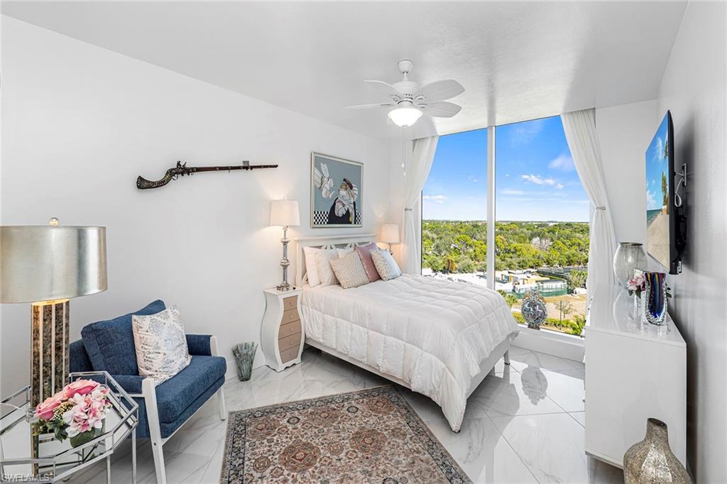 Bedroom with a ceiling fan, marble finish flooring, and floor to ceiling windows