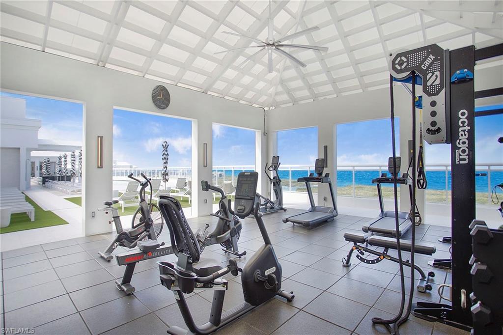 Rooftop Exercise room featuring a water view, high vaulted ceiling, and ceiling fan