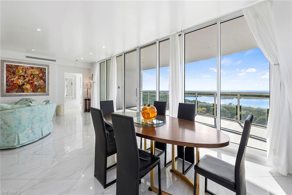 Dining space featuring recessed lighting, a water view, and a wall of windows