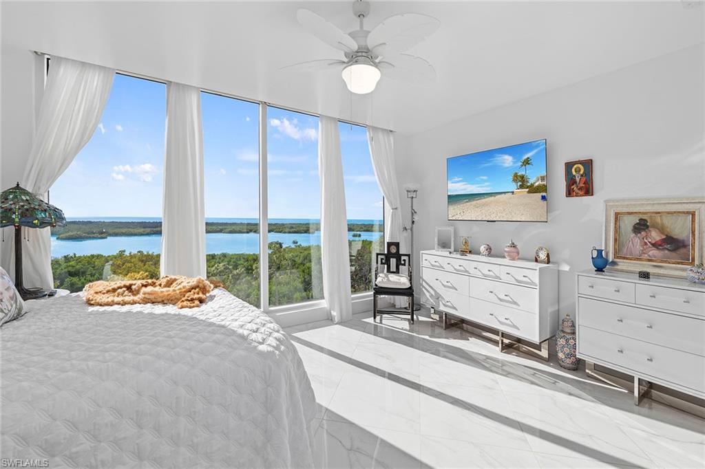 Bedroom featuring a ceiling fan, access to exterior, and marble tiled flooring
