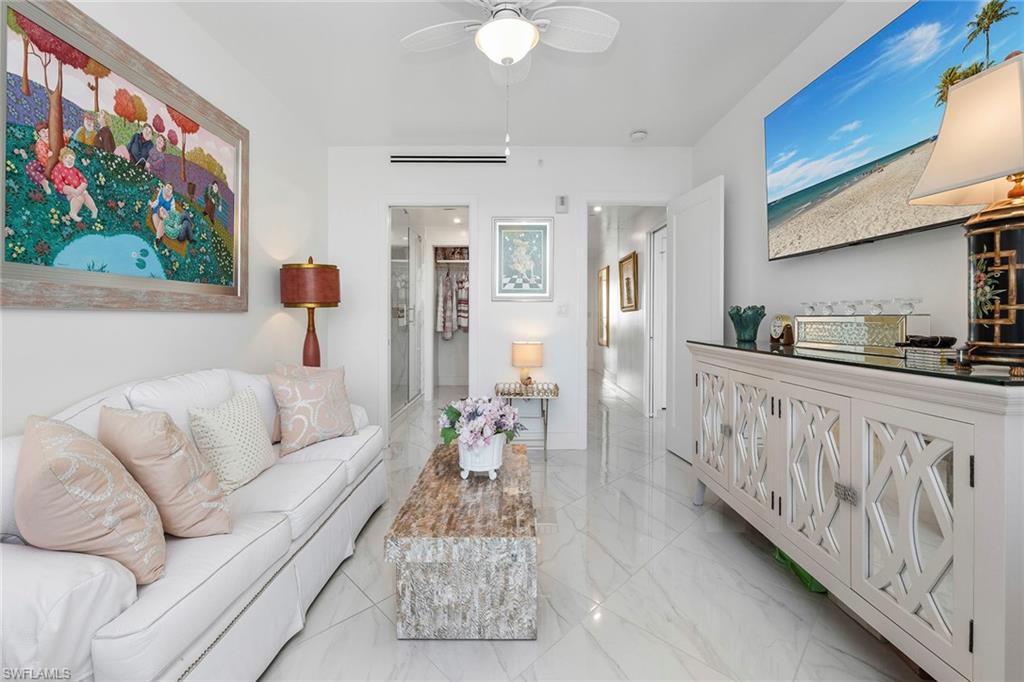 Living room with ceiling fan and light marble finish flooring