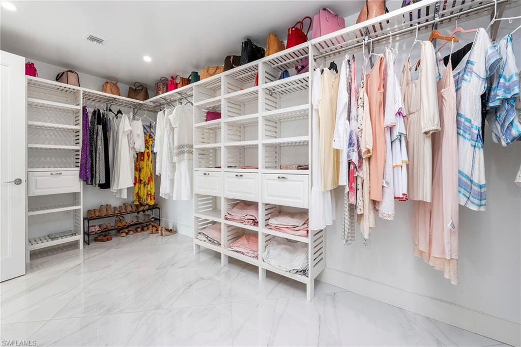 Walk in closet with light marble finish flooring
