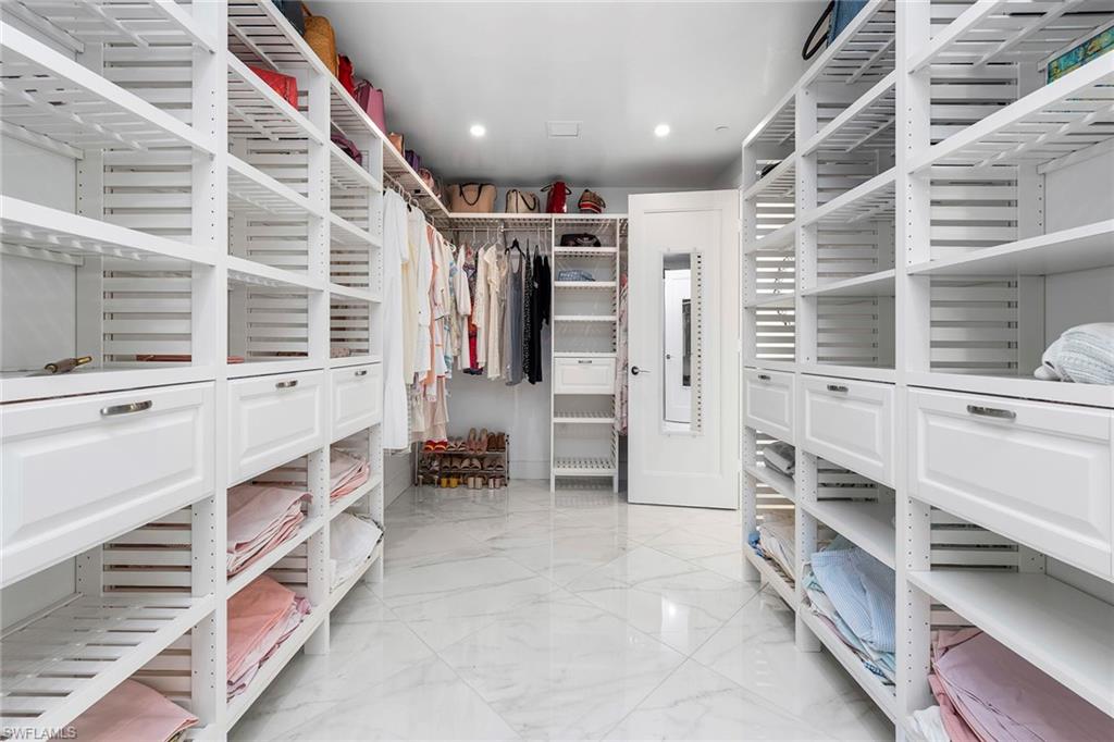 Walk in closet featuring light marble finish flooring