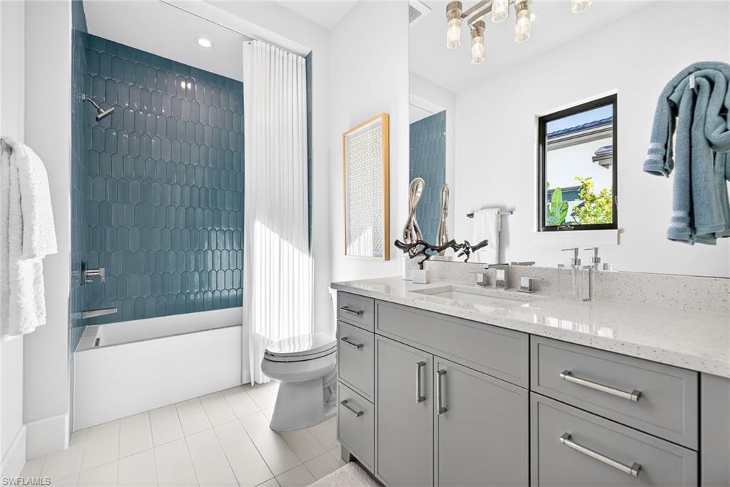 Full guest bathroom 3, large vanity, beautifully tiled bathtub / shower combination with light tile patterned floors