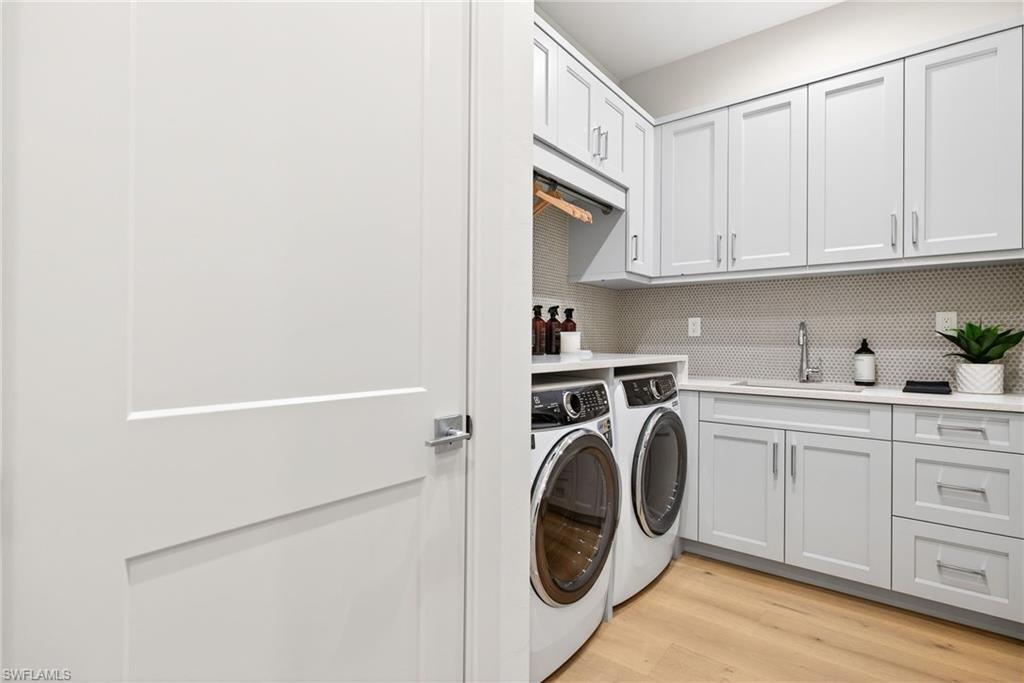Laundry area with lots of  cabinet space for storage , wood floors, and independent full size washer and dryer