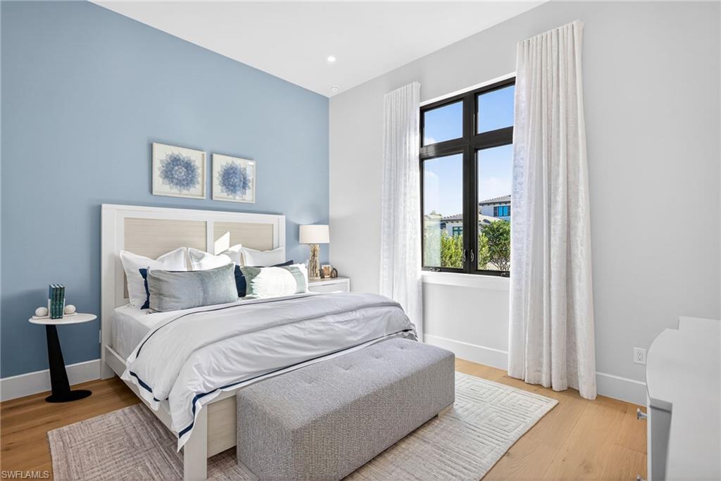 Guest bedroom 1 features a pretty blue accent wall and coastal contemporary design.