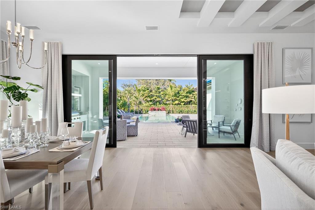 Dramatic view to the outdoor space from kitchen/dining area shows off the  gorgeous wood floors