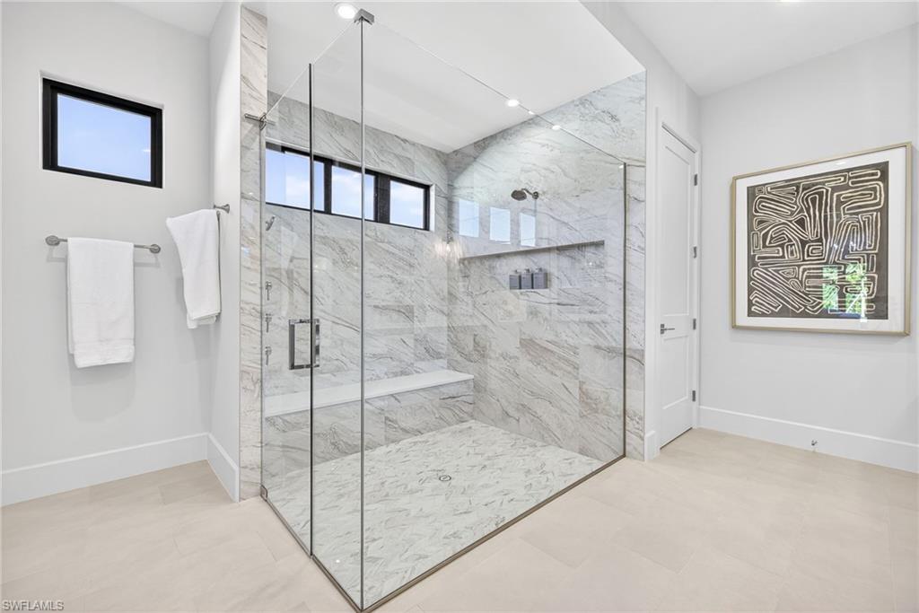 Spacious master suites bathroom with large marble tiled shower, the transom windows give plenty of  natural lighting