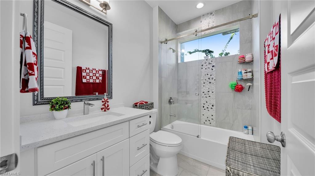 Bathroom with shower / bath combination with glass door and vanity