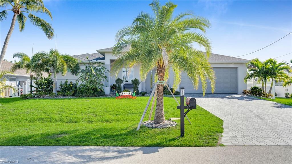View of front of property with a front lawn, decorative driveway, stucco siding, and a garage
