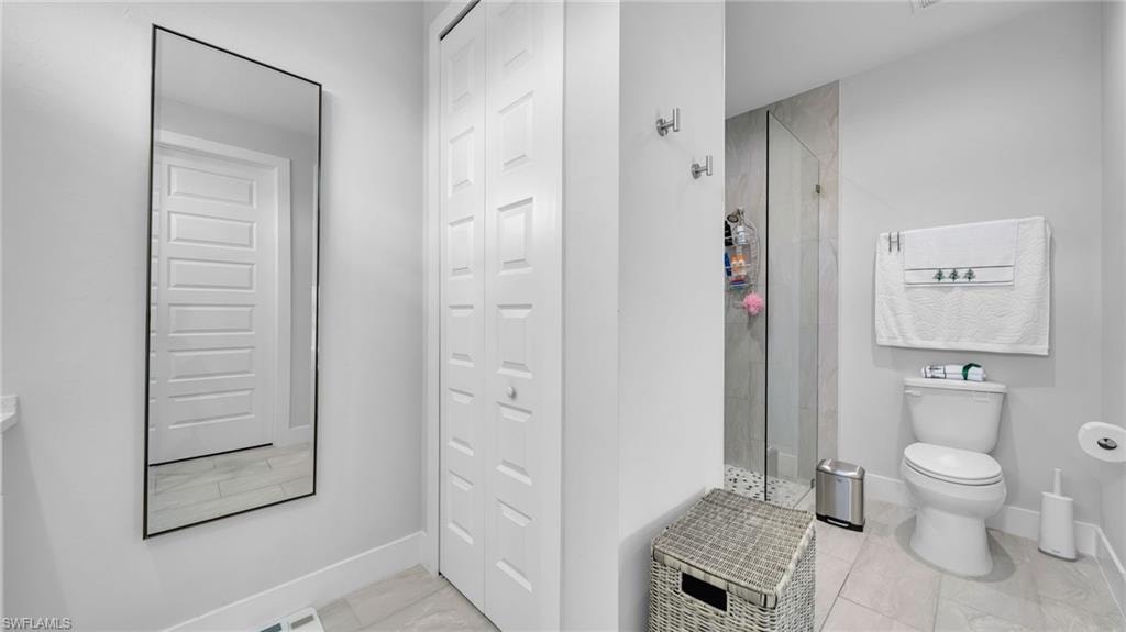 Bathroom featuring a shower stall and a closet