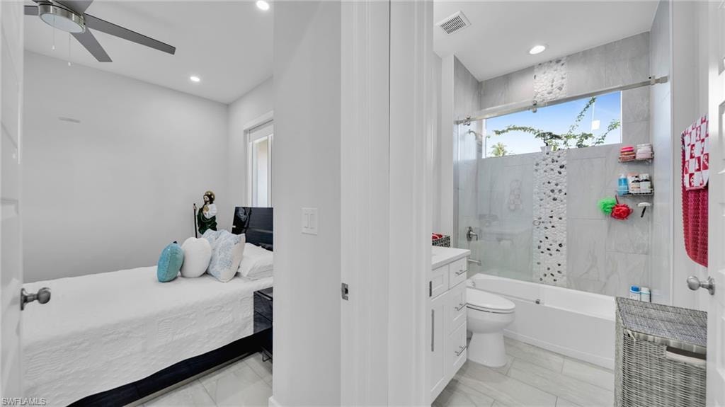 Full bath with vanity, shower / bath combo with shower curtain, connected bathroom, light marble finish floors, and recessed lighting