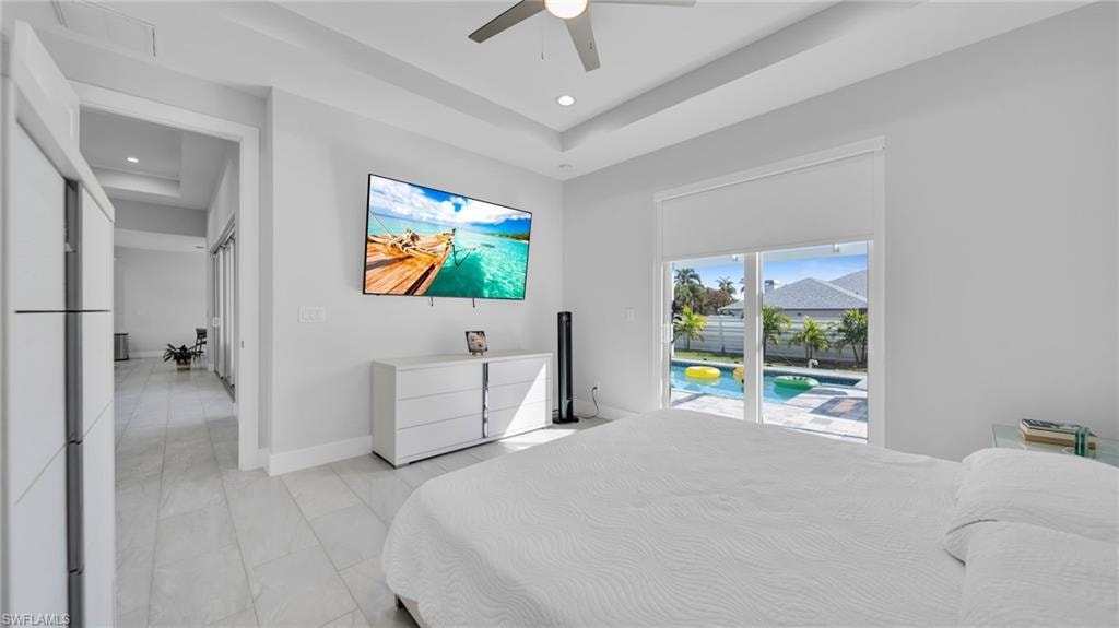 Bedroom featuring a raised ceiling, access to exterior, a ceiling fan, and recessed lighting