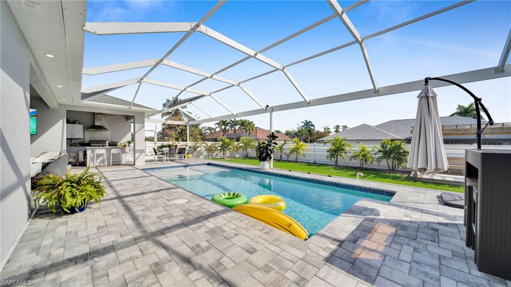 Swimming pool with a patio, a sunroom, glass enclosure, and area for grilling