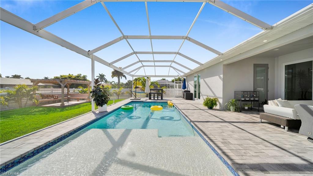 Outdoor pool with a patio area, a lanai, a sunroom, and a yard