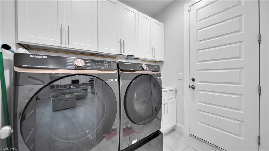 Laundry room featuring washer and clothes dryer and cabinet space