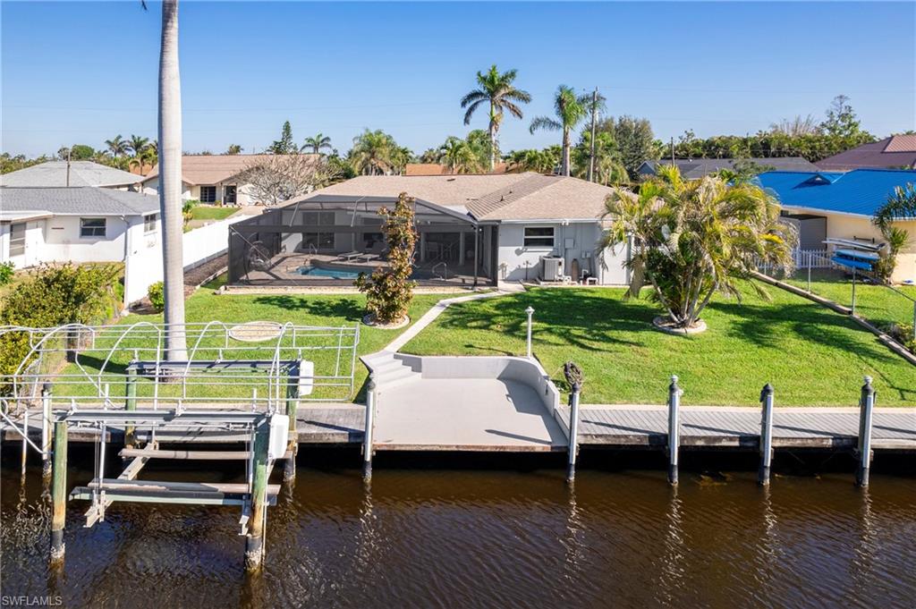 Dock featuring a water view, glass enclosure, a sunroom, and boat lift