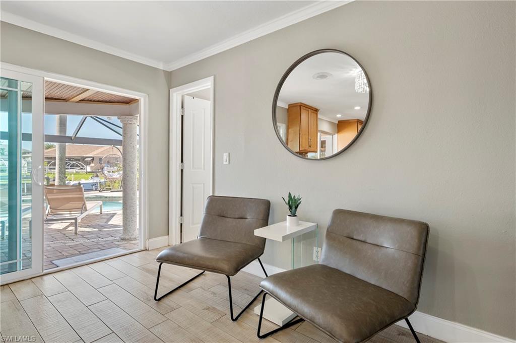 Sitting room with a sunroom, wood tiled floors, and crown molding