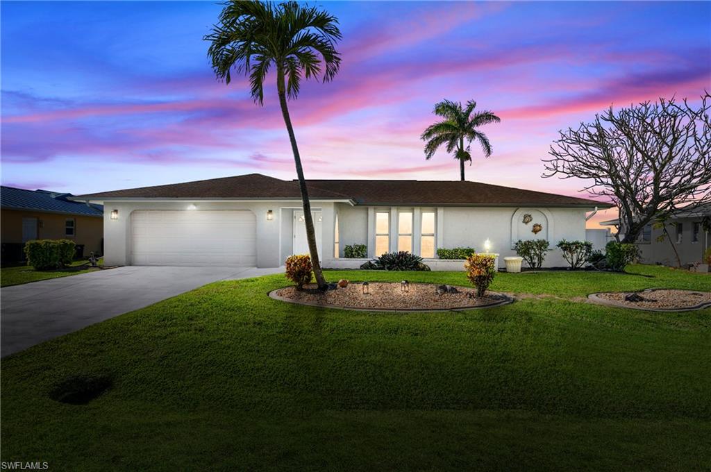Ranch-style home with stucco siding, driveway, a front lawn, and an attached garage