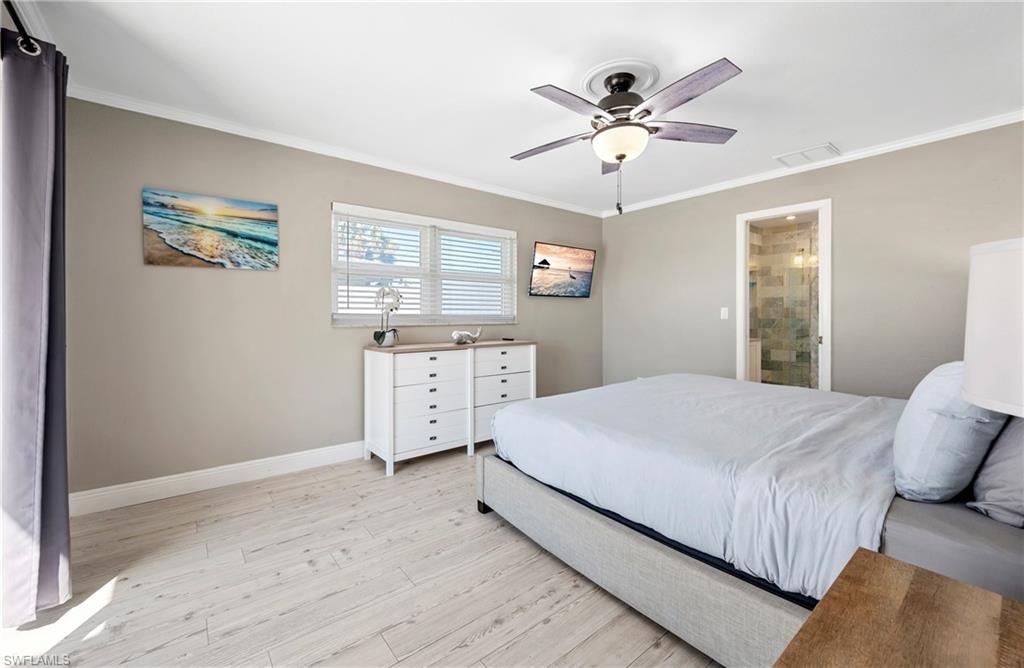 Bedroom with light wood-type flooring, crown molding, and a ceiling fan