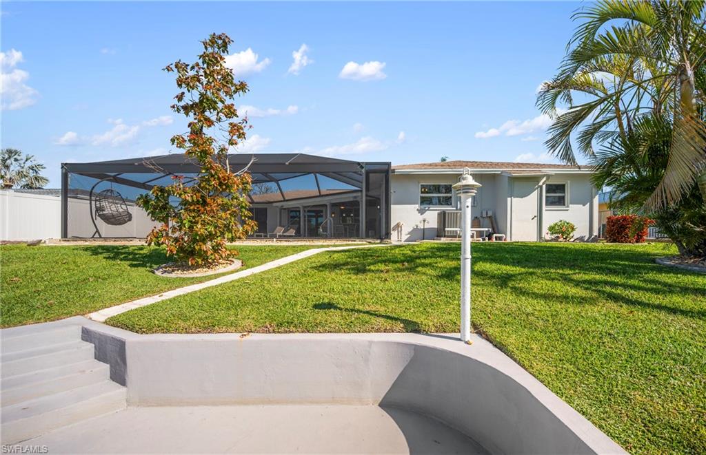 Back of house featuring a lanai, stucco siding, a sunroom, and a patio