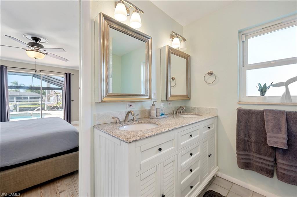 Full bath featuring double vanity, plenty of natural light, ensuite bath, and ceiling fan
