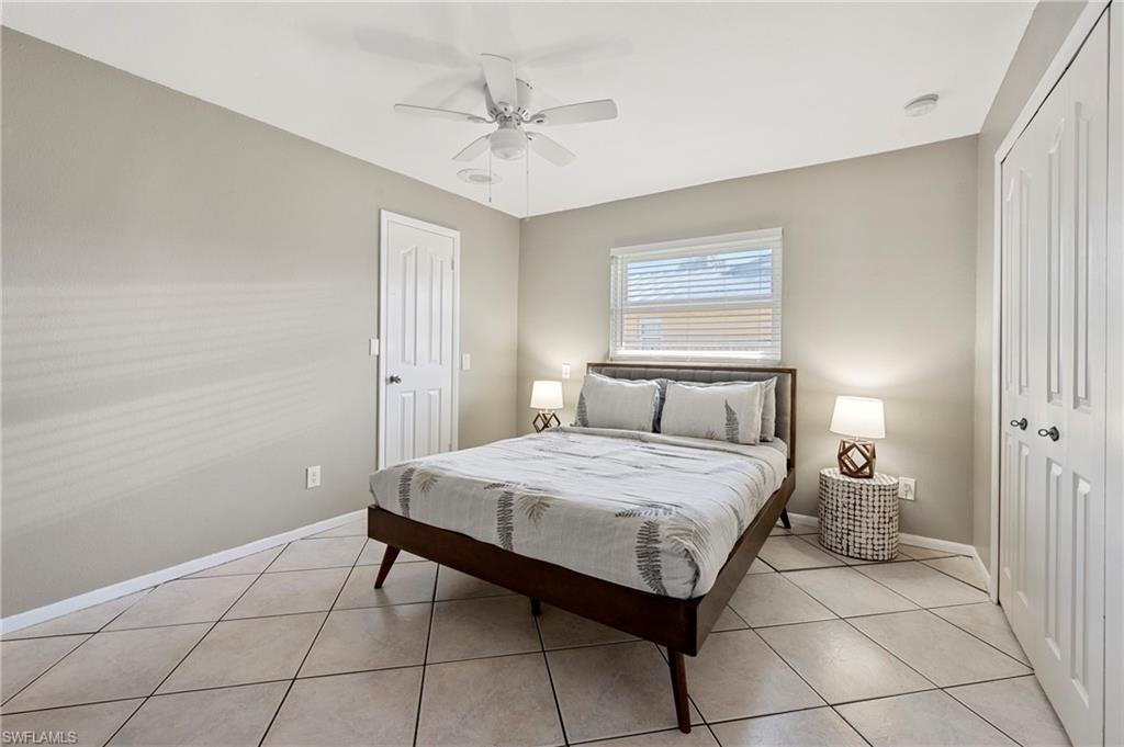 Bedroom featuring a closet, light tile patterned floors, and ceiling fan
