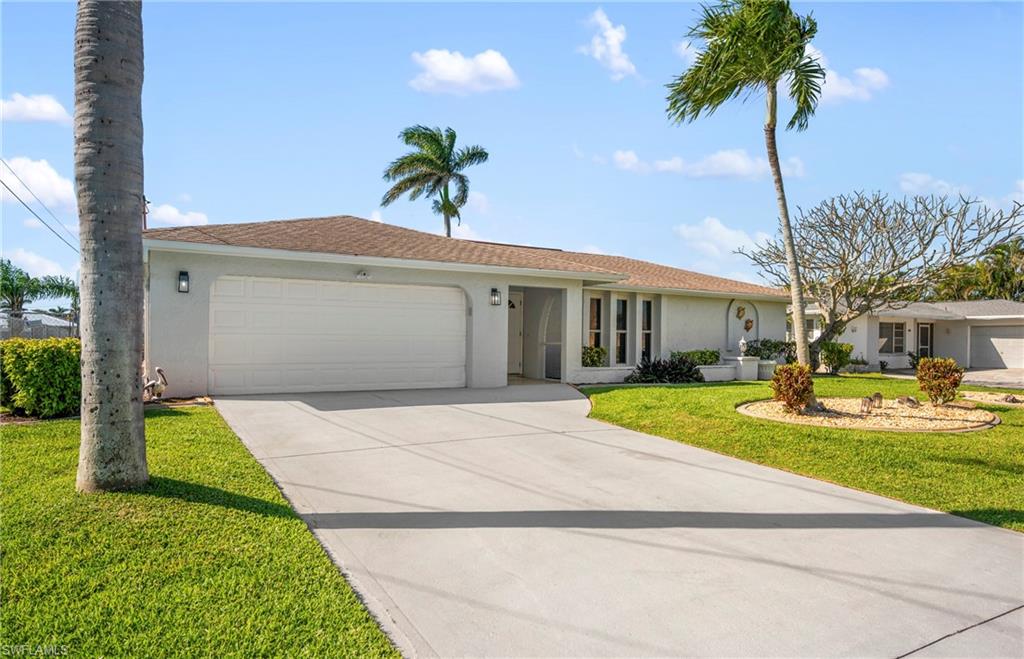 Single story home with stucco siding, concrete driveway, an attached garage, and a front lawn