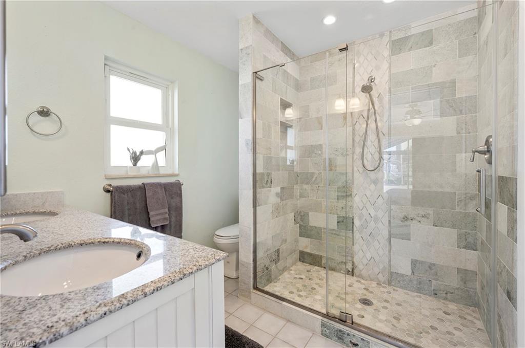 Full bathroom featuring vanity, a stall shower, light tile patterned floors, and recessed lighting