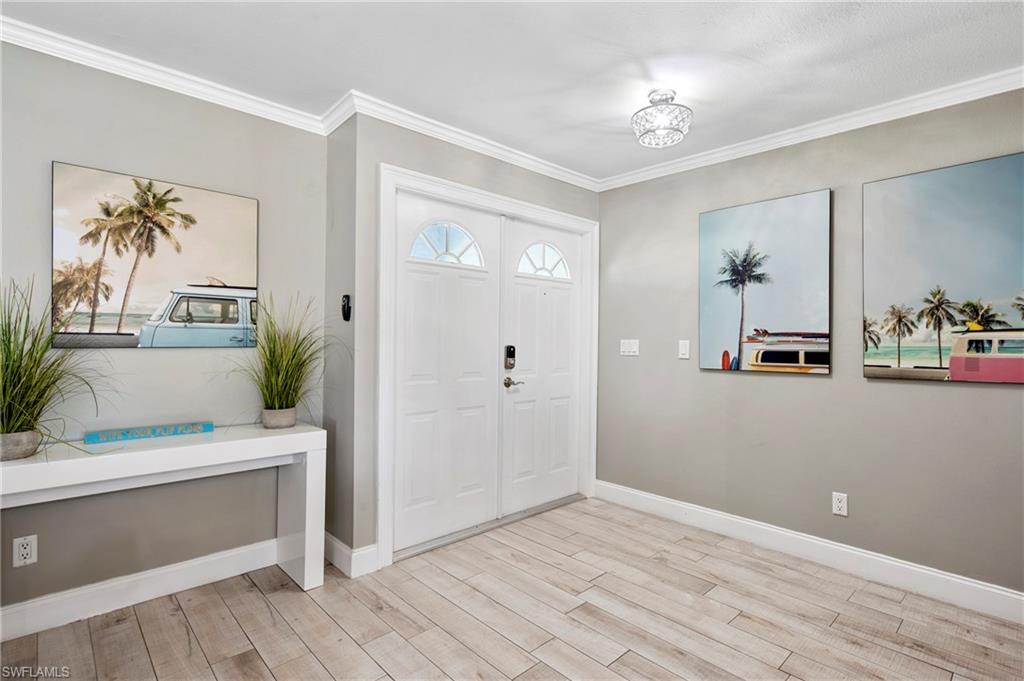 Entrance foyer with light wood finished floors and crown molding