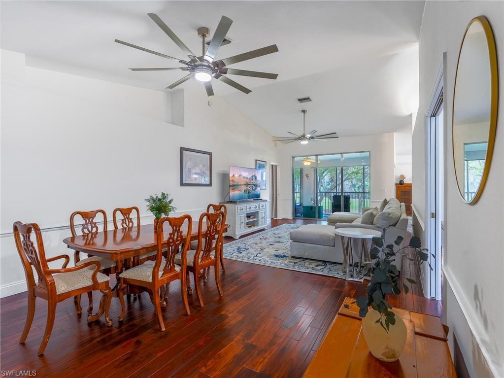Dining area featuring dark wood finished floors, lofted ceiling, and ceiling fan
