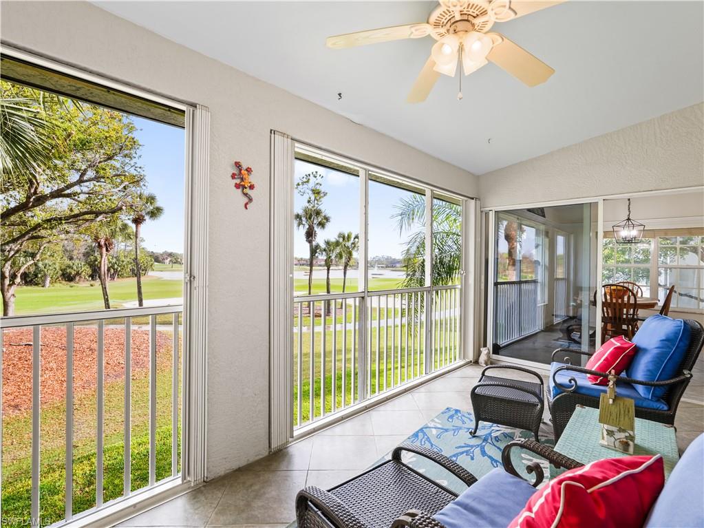Patio with a textured wall, view of golf course, plenty of natural light, and tile patterned flooring