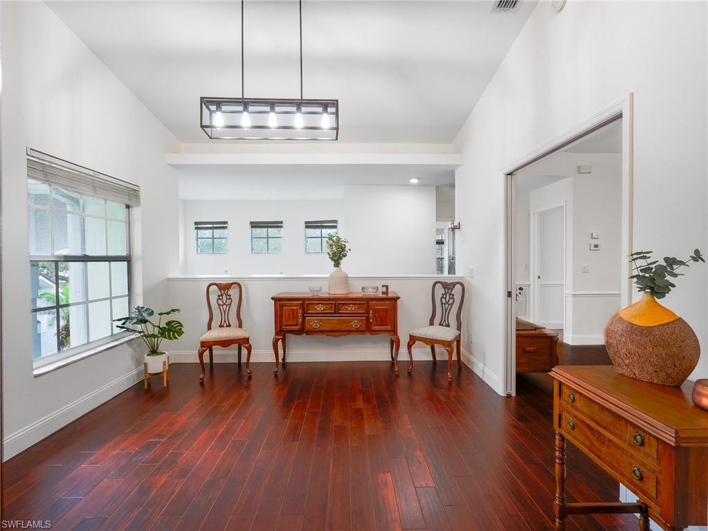 Living area featuring dark wood-type flooring and baseboards
