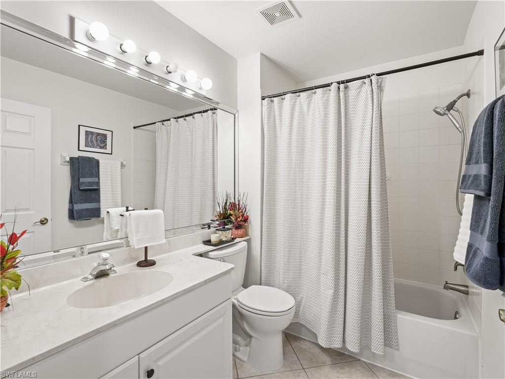 Full bathroom featuring vanity, light tile patterned flooring, and shower / bathtub combination with curtain