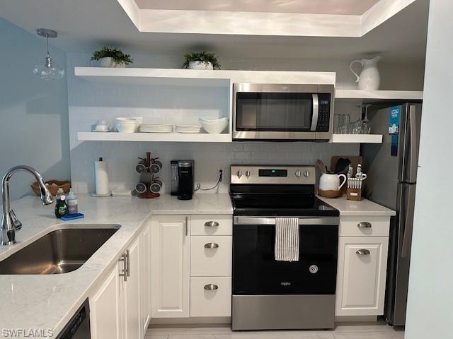 Kitchen with open shelves, stainless steel appliances, white cabinetry, light stone countertops, and backsplash