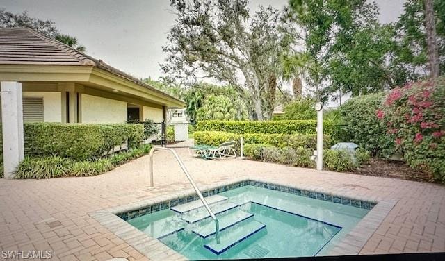 View of pool with a hot tub and a patio