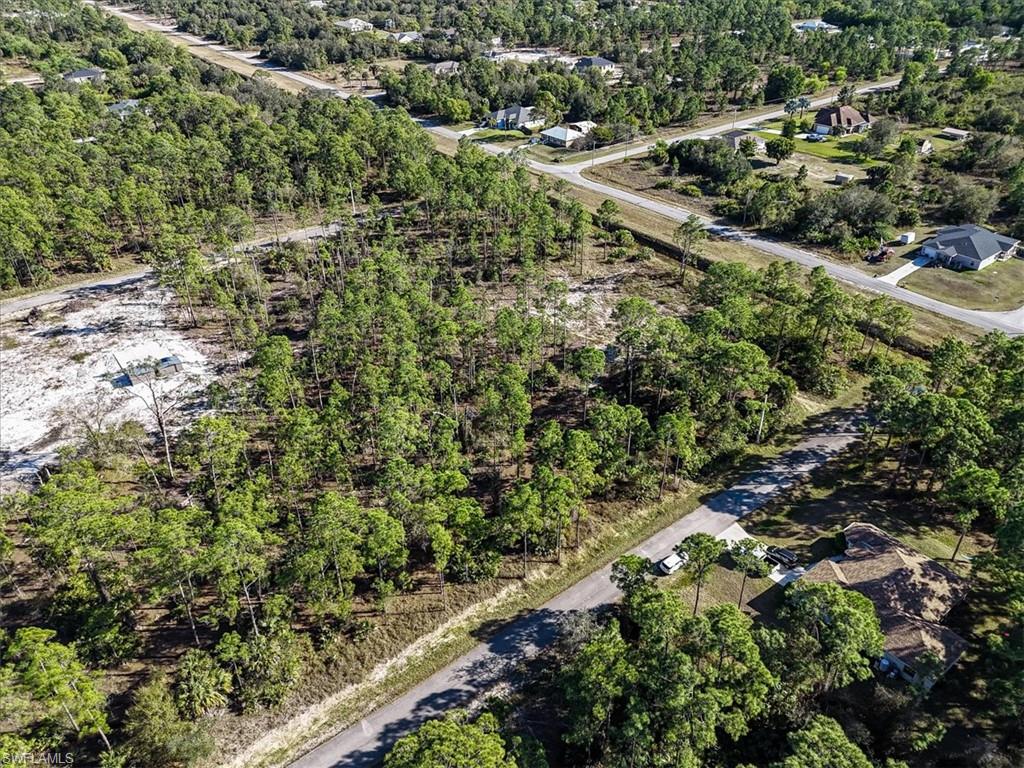 Aerial view of property and surrounding area featuring a forest