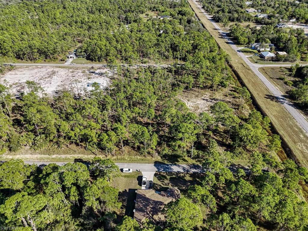 Aerial view of property and surrounding area featuring a heavily wooded area