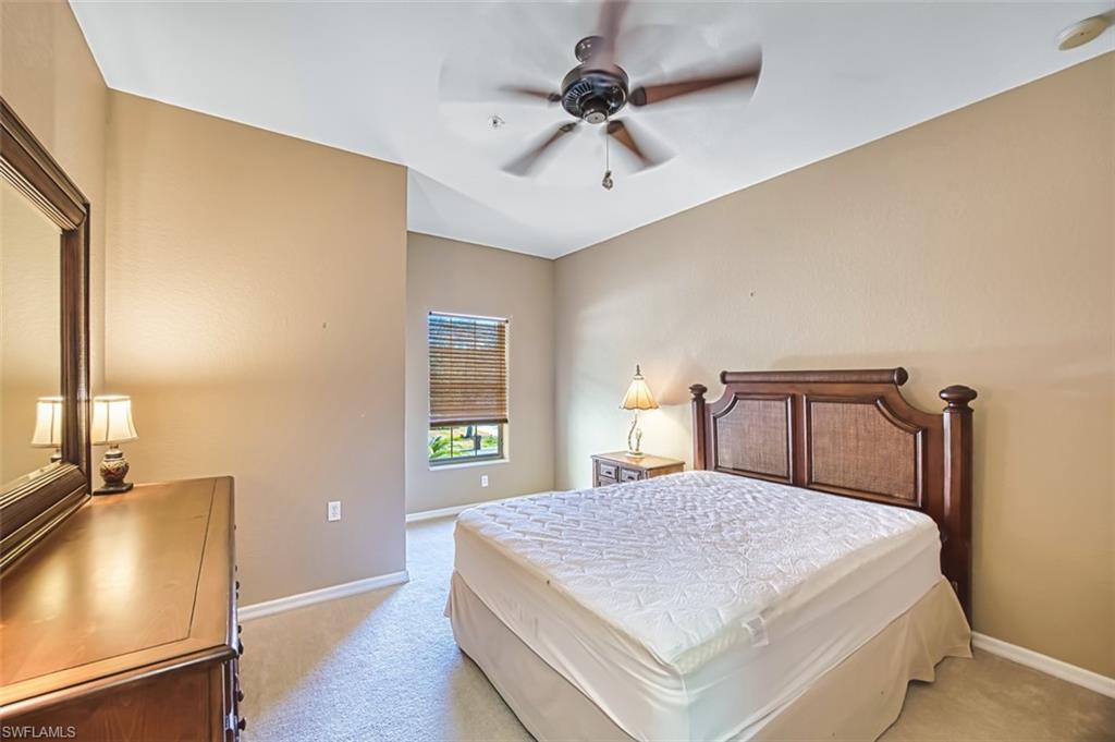 Bedroom with light carpet and a ceiling fan