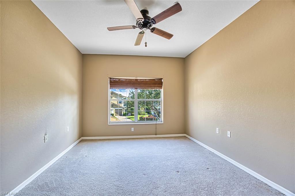 Unfurnished room featuring carpet, ceiling fan, and a textured wall