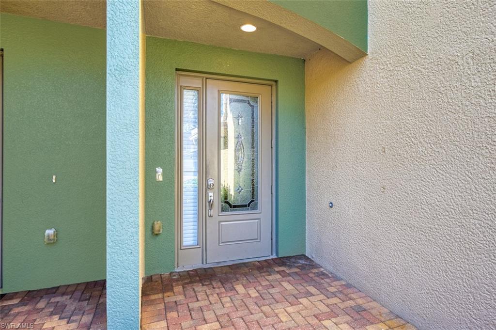 Doorway to property featuring stucco siding