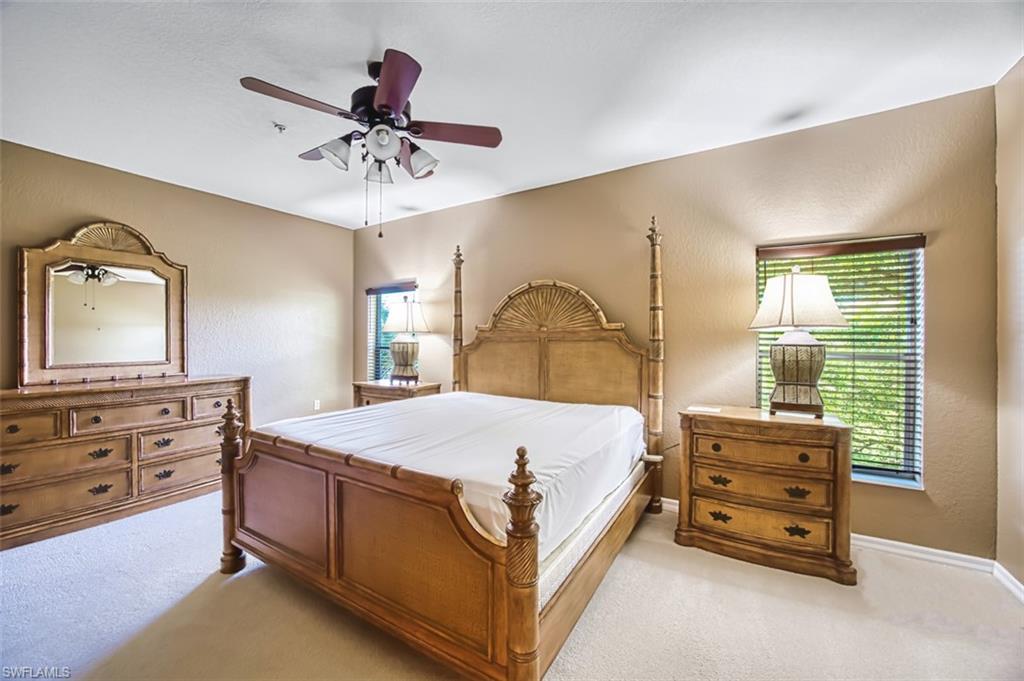 Bedroom featuring a textured wall, carpet flooring, and a ceiling fan