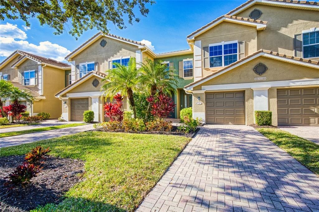 Mediterranean / spanish home featuring stucco siding, decorative driveway, a front yard, and an attached garage