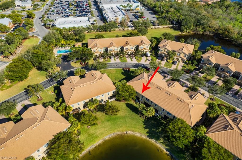 Aerial view of property and surrounding area featuring a large body of water and nearby suburban area