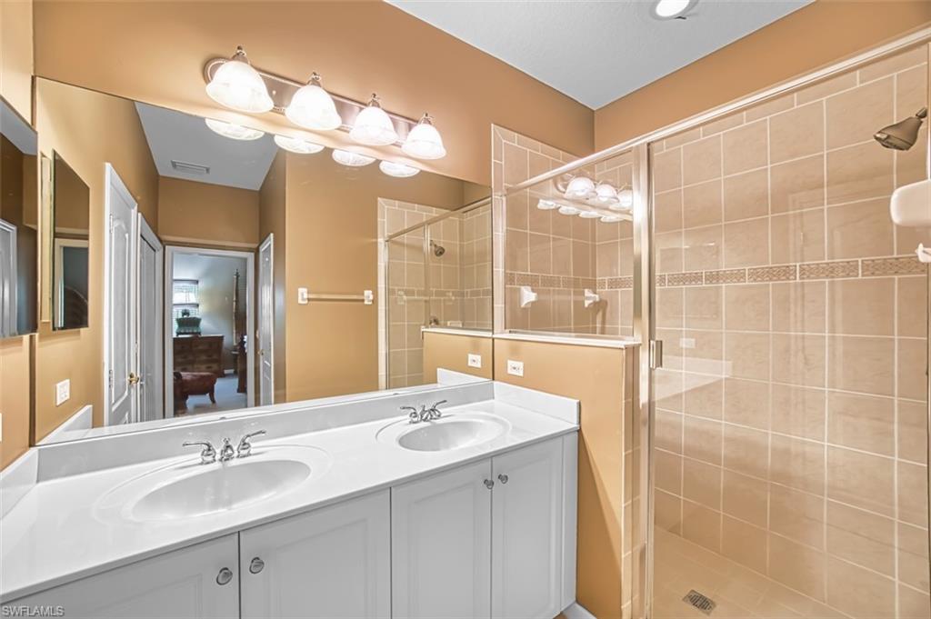 Bathroom featuring double vanity and a shower stall