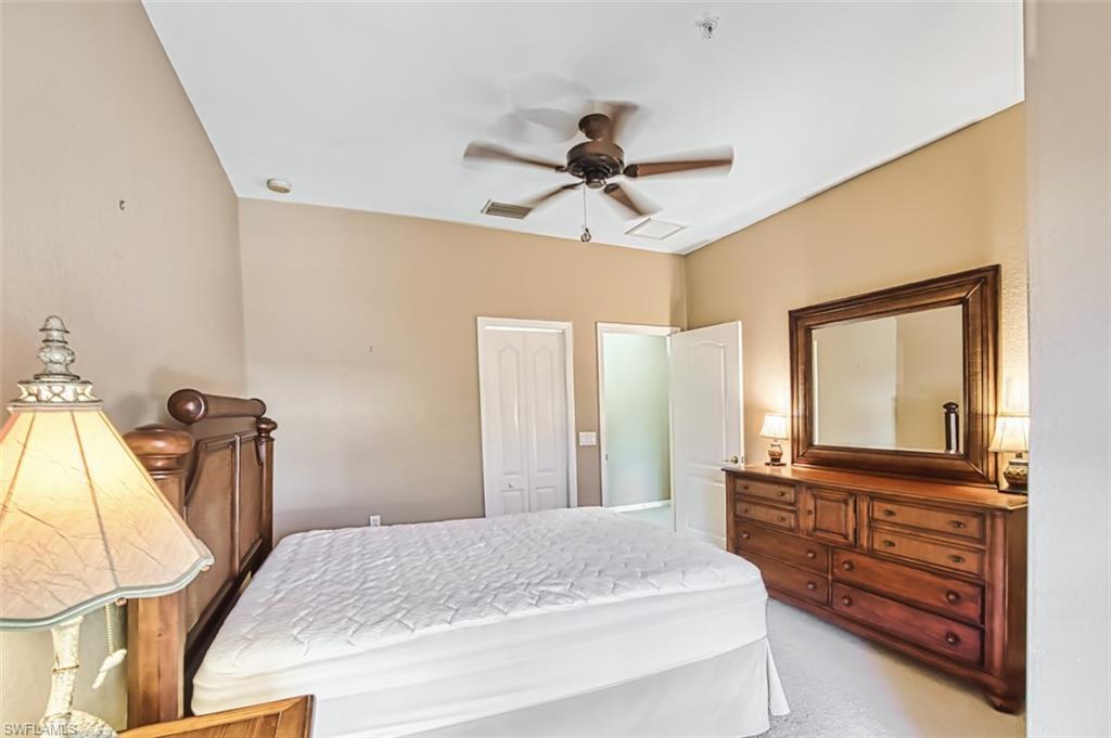 Bedroom featuring a closet, light carpet, and ceiling fan